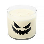 The 3 Wick Clear Tumbler Halloween Candle with Scary Pumpkin (Face #4) features a white scented candle in a clear glass jar with a jagged jack-o’-lantern face—perfect for Halloween décor.