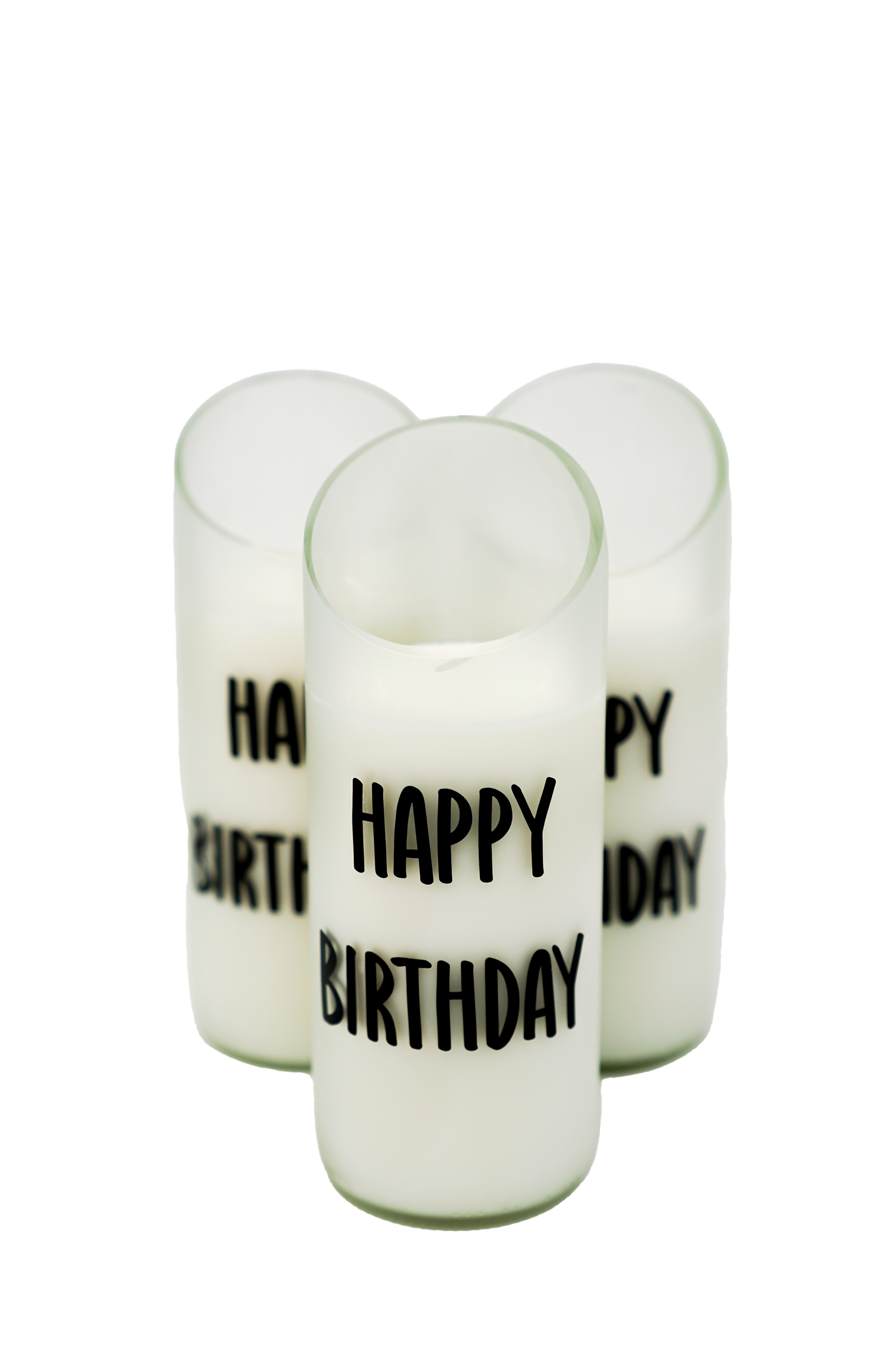 Three Quoted - Recycled Cut Wine Bottles candles in frosted glass holders, each featuring "HAPPY BIRTHDAY" in bold black text, are closely arranged on a white background.