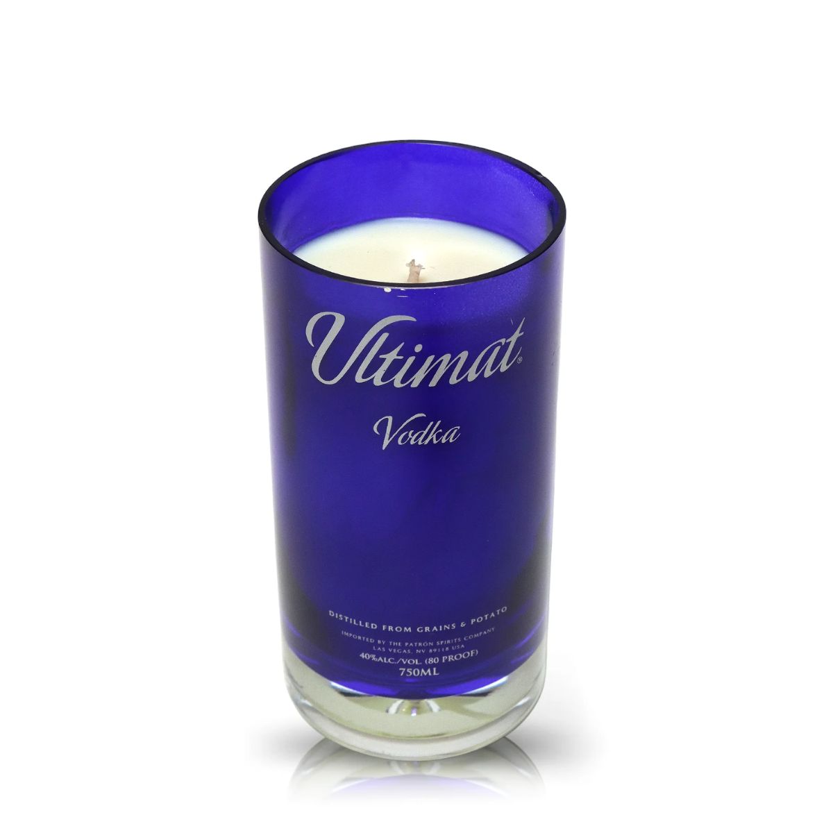 The Recycled Ultimat Vodka Candle features a blue glass holder made from a repurposed Ultimat Vodka bottle and contains a white candle with a visible wick.