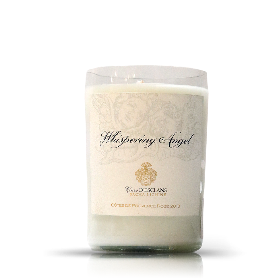 The Recycled Whispering Angel Rose Wine Candle is a white upcycled candle in a glass holder with a "Whispering Angel, Caves D'Esclans, Côtes de Provence Rosé 2018" label—ideal for fans of wine bottle candles and eco-friendly décor.
