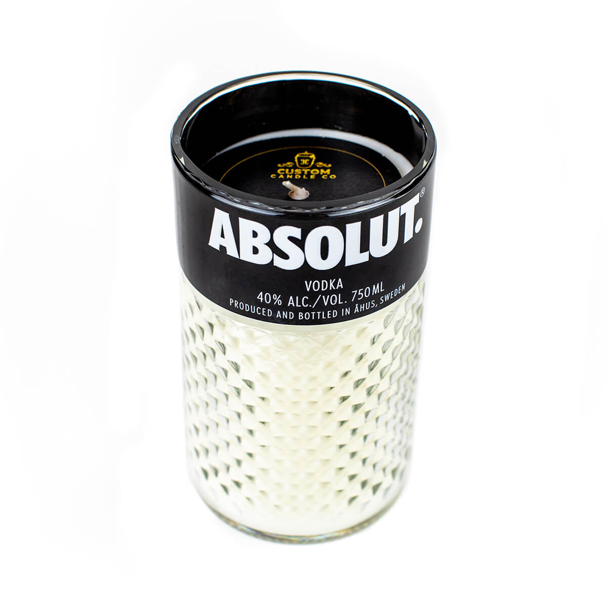 The Recycled Vodka Candle – Absolut is a hand-poured white candle in a glass container made to look like an Absolut Vodka bottle, complete with authentic brand labels and alcohol content details.