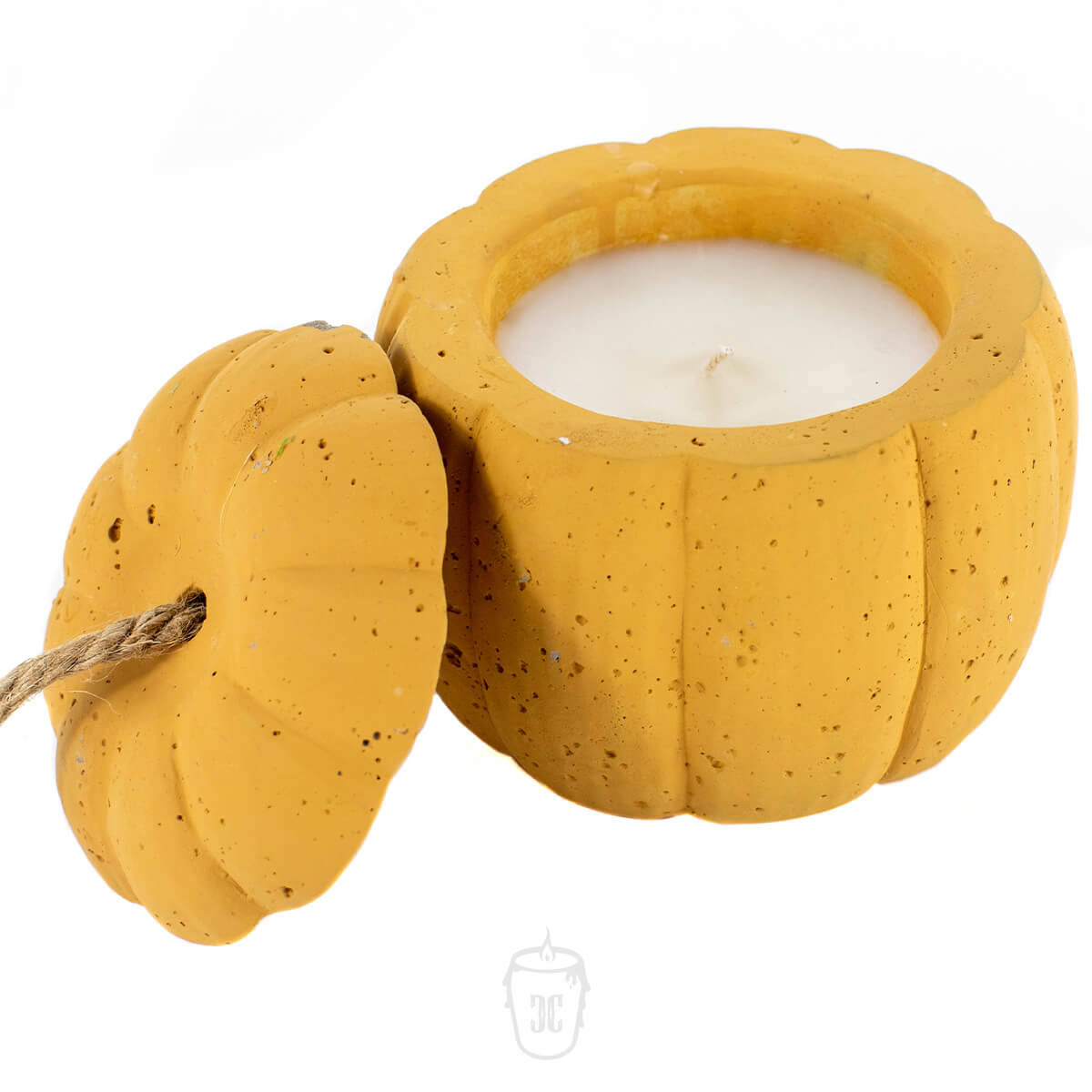 A Yellow Cement Candle in a pumpkin-shaped yellow container with the lid removed and set beside it.