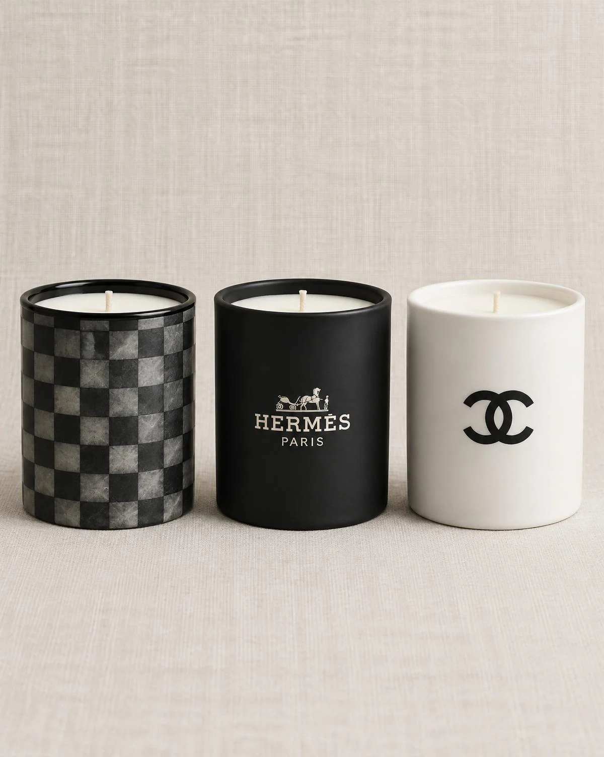 Black, white and patterned designer-inspired jar candles arranged on marble beside soft furnishings