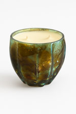 The Aqua Glow Candle features creamy wax with two unlit wicks in a green, textured glass holder, presented as a luxury scented candle set on a plain white background.