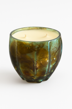 The Aqua Glow Candle features creamy wax with two unlit wicks in a green, textured glass holder, presented as a luxury scented candle set on a plain white background.
