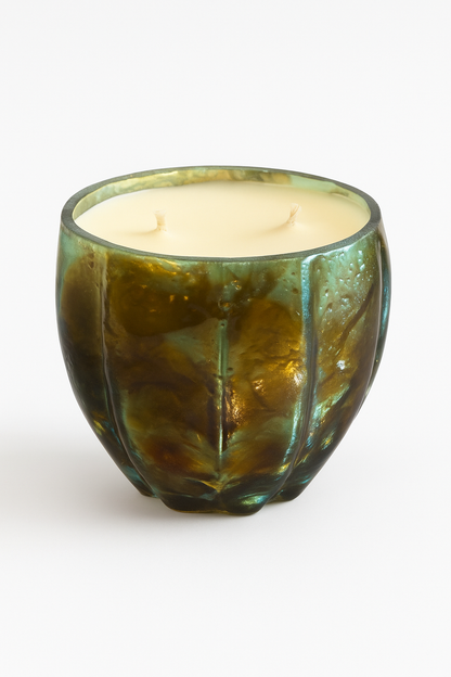 The Aqua Glow Candle features creamy wax with two unlit wicks in a green, textured glass holder, presented as a luxury scented candle set on a plain white background.