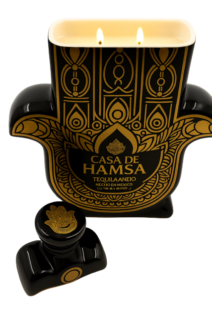 The Casa de Hamsa Añejo Tequila Candle features a black and gold hamsa-shaped tequila bottle with a matching stopper, paired with a recycled hand-poured natural soy candle.