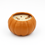 The Large Orange Ceramic Pumpkin Candle, a natural soy candle topped with dried spices in a ceramic pumpkin vessel, is displayed against a plain white background.