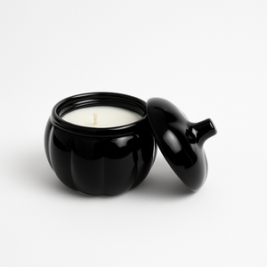 The Midnight Pumpkin Candle features a black pumpkin holder with a lid and a hand-poured soy candle inside—a single wick design, perfect for adding cozy fall décor to your space. Displayed on a white background.