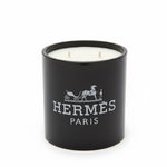 The Designer Paris Candle is a black, double-wick candle made from coconut-apricot wax, featuring the Hermès logo and white horse-drawn carriage design on the front—a true statement of luxury.