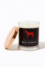 The Custom Red Horse Candle features a rose gold lid and a black label with a red horse silhouette and the text "Red Horse by David Burke, White Plains, NY.