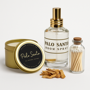The Palo Santo Box Set includes a tin candle, a Palo Santo room spray, matches in a small jar, and several pieces of Palo Santo wood arranged on a white surface.