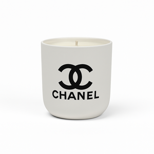 The Designer Ceramic Candle is a white soy candle in a ceramic cup featuring the black Chanel logo and brand name on the front, displayed against a plain white background.