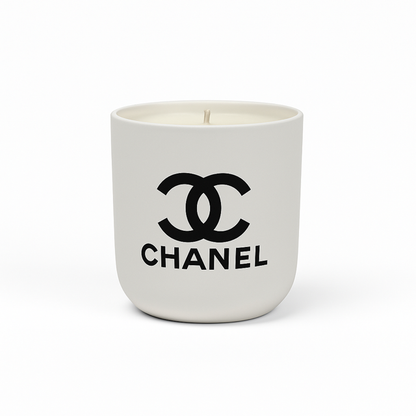 The Designer Ceramic Candle is a white soy candle in a ceramic cup featuring the black Chanel logo and brand name on the front, displayed against a plain white background.