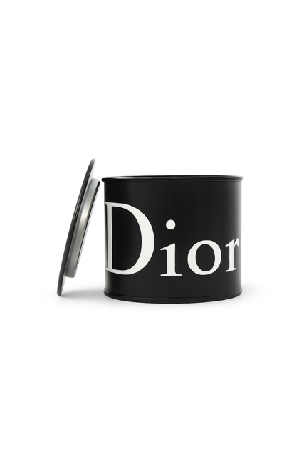 The Designer Black Paint Can Candle is a black, cylindrical candle with a partially open lid and "Dior" in large white letters, hand poured from soy for a luxurious, stylish touch to any space.