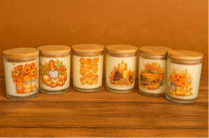 Six glass jars with wooden lids from the Fall Harvest Candle Collection feature autumn designs—sunflowers, pumpkins, candles, and a truck on a brown background—perfect for displaying your favorite hand-poured or Fall Harvest Candle.