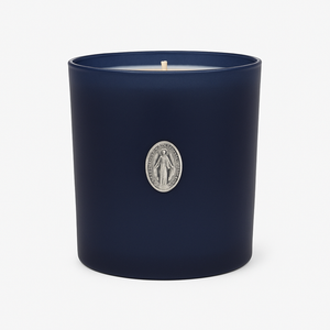 The Boxed Blessed Mother Candle is hand-poured with coconut-apricot wax in a navy matte glass, featuring a silver religious medallion, for a serene and scented experience.