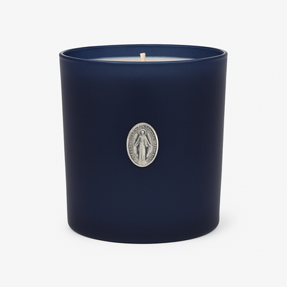 The Boxed Blessed Mother Candle is hand-poured with coconut-apricot wax in a navy matte glass, featuring a silver religious medallion, for a serene and scented experience.