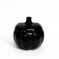 The Midnight Pumpkin Candle features a glossy black ceramic pumpkin-shaped container with a lid. Hand-poured with soy wax, it’s an elegant fall accent perfect for seasonal décor. Shown against a plain white background.