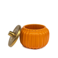 The Golden Pumpkin Candle, an orange pumpkin-shaped ceramic container with a gold-colored lid, sits on a white background—perfect as an autumn accent.