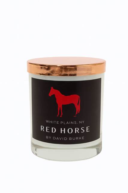 The Custom Red Horse Candle features all-natural soy wax in a glass jar with a copper lid and black label showing a red horse silhouette and "White Plains, NY Red Horse by David Burke," adding elegance to any space.