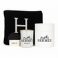 The Designer Paris Gift Set includes a black pillow with a bold white "H," a white Hermès candle, a cotton throw, a white box, and a small "Paris" card stylishly arranged together.