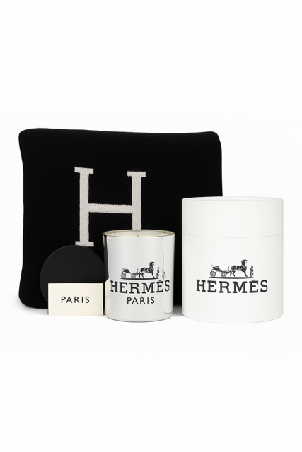 The Designer Paris Gift Set includes a black pillow with a bold white "H," a white Hermès candle, a cotton throw, a white box, and a small "Paris" card stylishly arranged together.