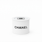 A Designer Paint Can Candle in white, shaped like a cylindrical container with the CHANEL logo and black text on the side, is displayed against a plain white background.
