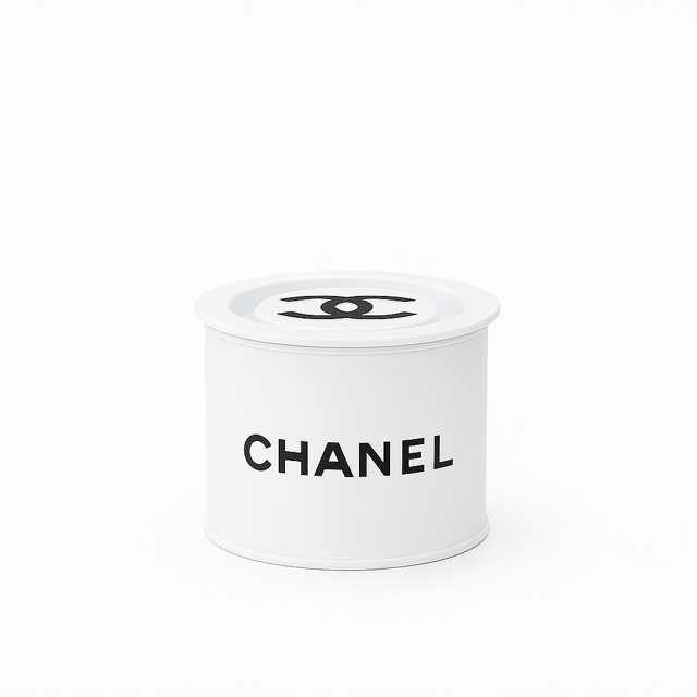 A Designer Paint Can Candle in white, shaped like a cylindrical container with the CHANEL logo and black text on the side, is displayed against a plain white background.