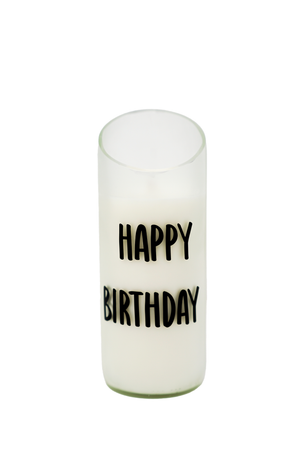 The Quoted - Recycled Cut Wine Bottles candle is a white "Happy Birthday" candle in a glass holder made from a recycled wine bottle, featuring "HAPPY BIRTHDAY" in bold black letters on the front.