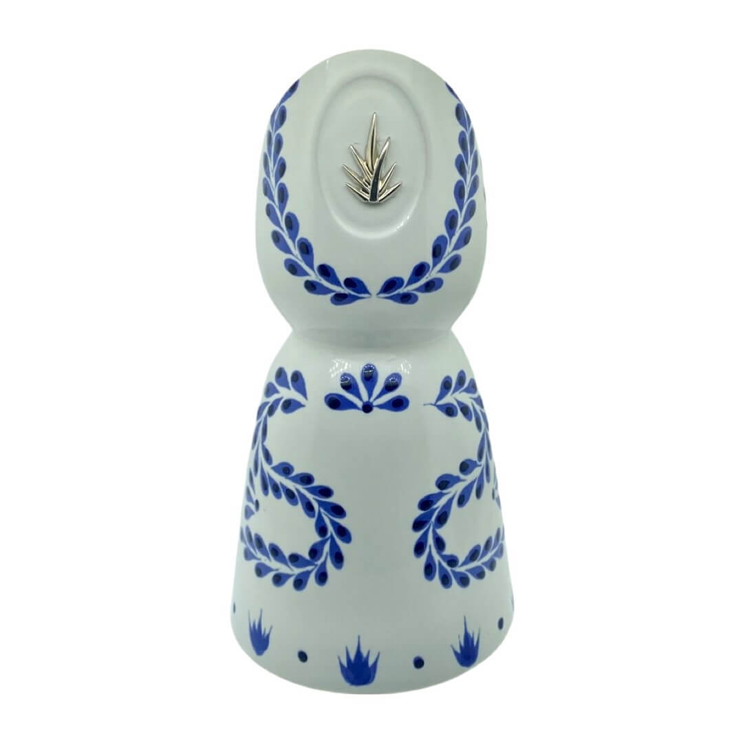 The Recycled Azul Tequila Curve Cut Candle features a white ceramic bottle with blue floral designs and a silver agave emblem, hand-poured with soy wax and photographed against a plain white background.