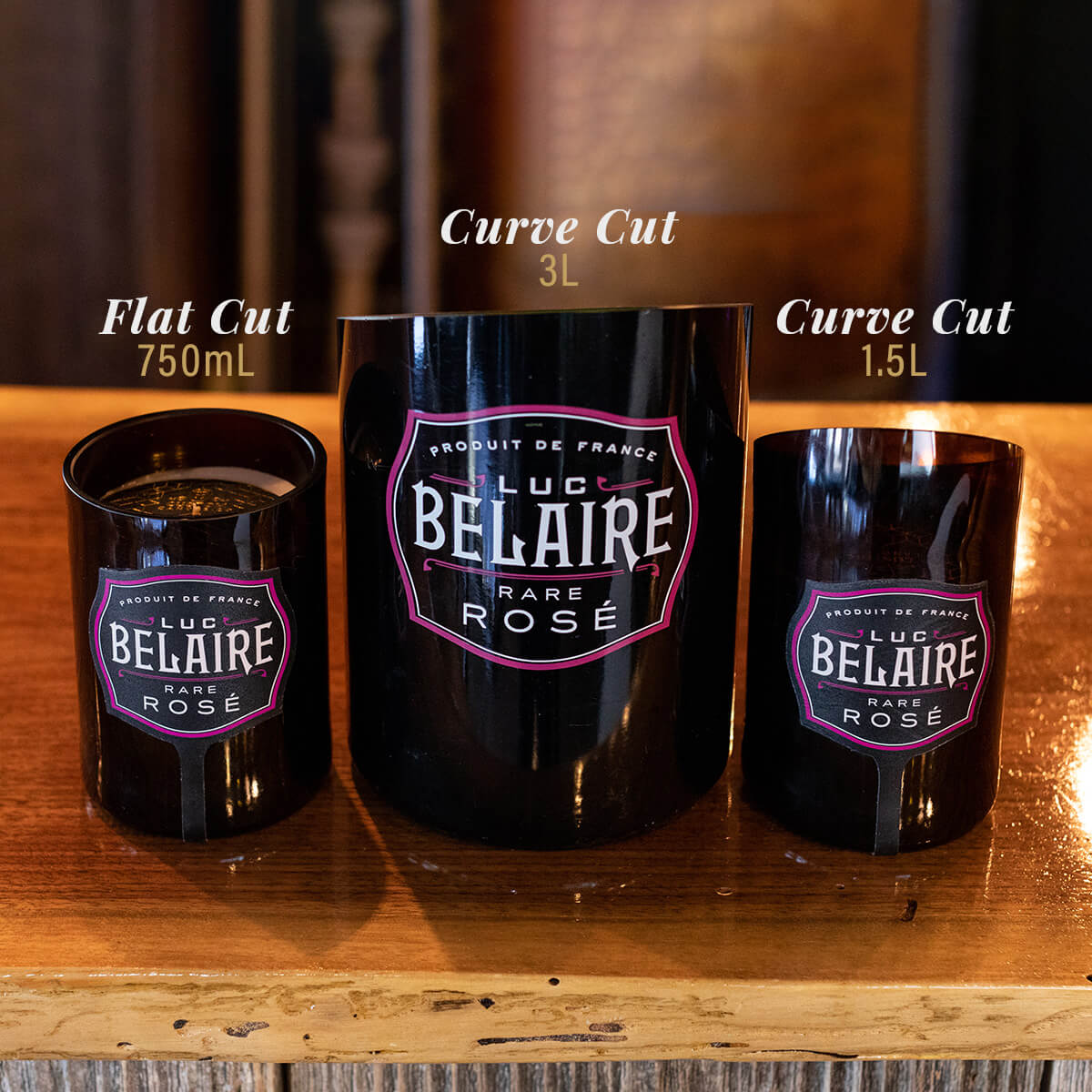 Three Recycled Champagne Candle – Luc Belaire Rare Rose on a wooden surface: a 750mL flat cut on the left, a 3L curve cut Hand Poured Soy Candle in the center, and a 1.5L curve cut on the right.