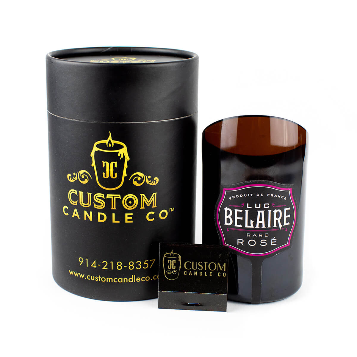A Recycled Champagne Candle – Luc Belaire Rare Rose in a hand-poured soy wax glass, paired with a black cylindrical box and small black matchbox, is displayed on a white background.