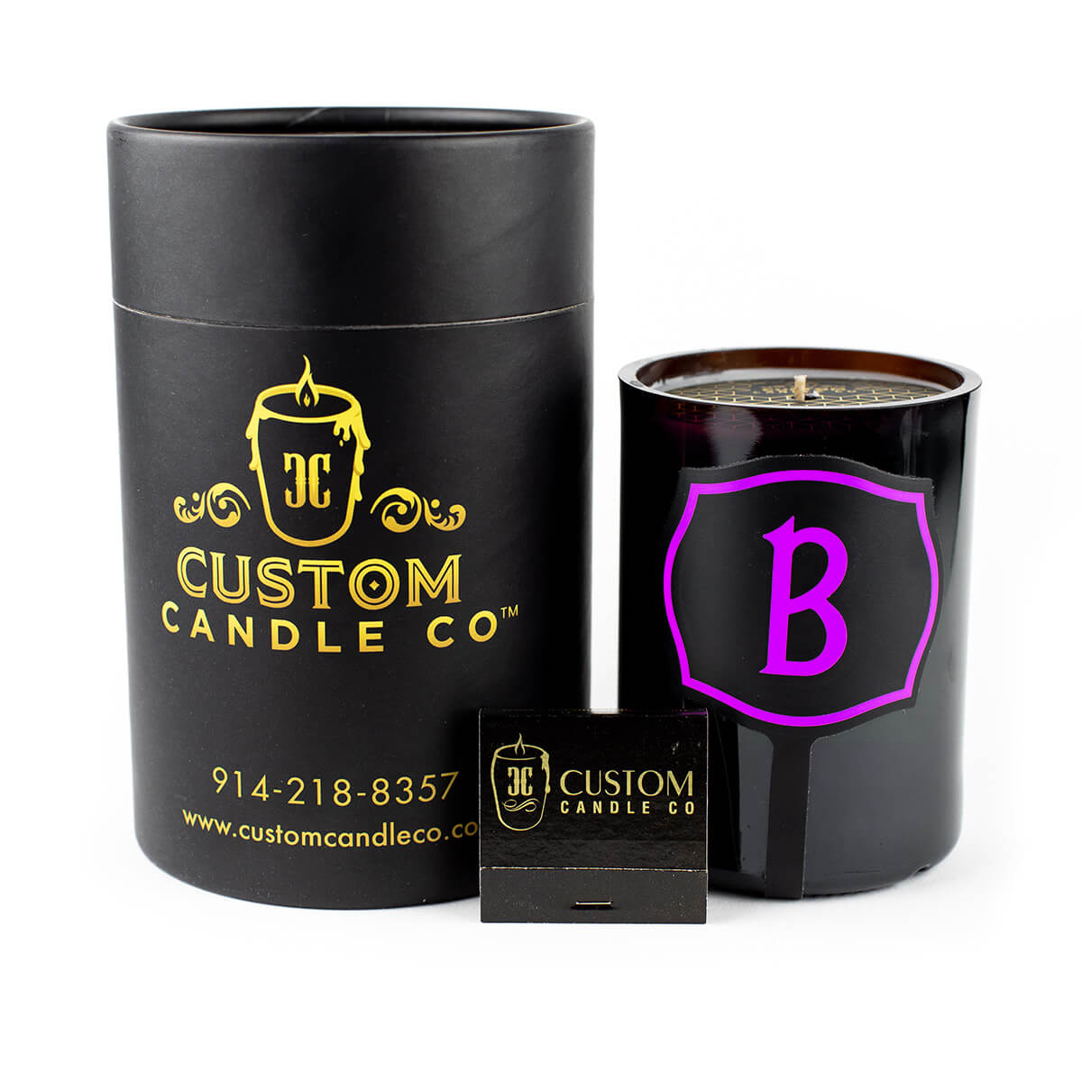 A black Recycled Champagne Candle – Luc Belaire Rose Fantome, featuring a purple "B," and a sleek black matchbox are displayed on a white background.