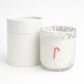 The Candy Cane Glass Candle features white marbled glass and a small candy cane design, shown beside a matching round white container.