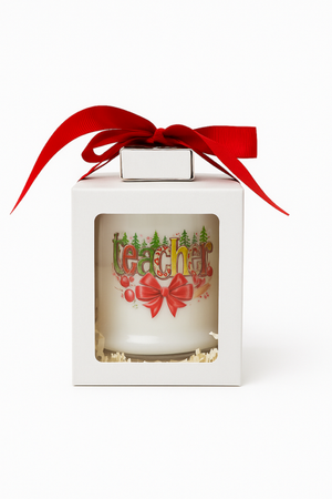 The Teacher's Christmas Candle with Matches is labeled "teacher," made from all-natural wax, features holiday decorations, and comes in a white box with a clear window topped with a red ribbon.