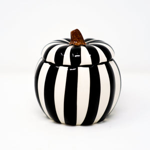 The Ceramic Large Black Line Pumpkin Candle, featuring black and white vertical stripes and a brown stem, adds festive charm and a striking accent to any space—perfect for seasonal décor or as a unique centerpiece.