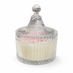 The Pressed Flower Candle comes in a clear, textured crystal glass jar with a lid. Hand-poured soy wax appears white with a hint of pink at the top.