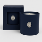 The Boxed Blessed Mother Candle, in dark blue coconut-apricot wax with a silver religious medallion, comes in a matching box featuring a window that displays the same medallion.