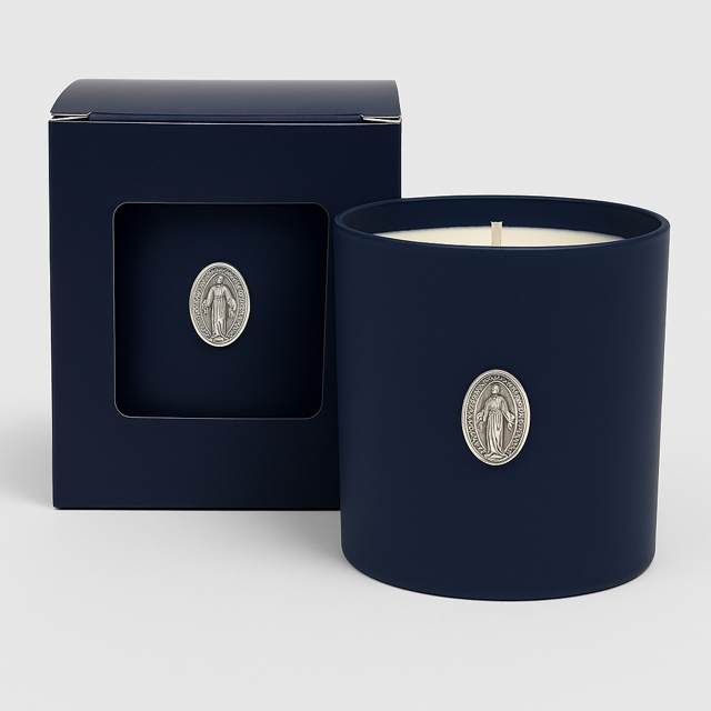 The Boxed Blessed Mother Candle, in dark blue coconut-apricot wax with a silver religious medallion, comes in a matching box featuring a window that displays the same medallion.