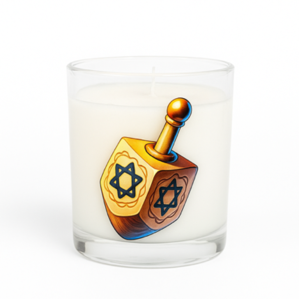The Dreidel Candle is a white candle in a clear glass holder with a dreidel and Star of David design—an ideal Hanukkah decoration for your home.