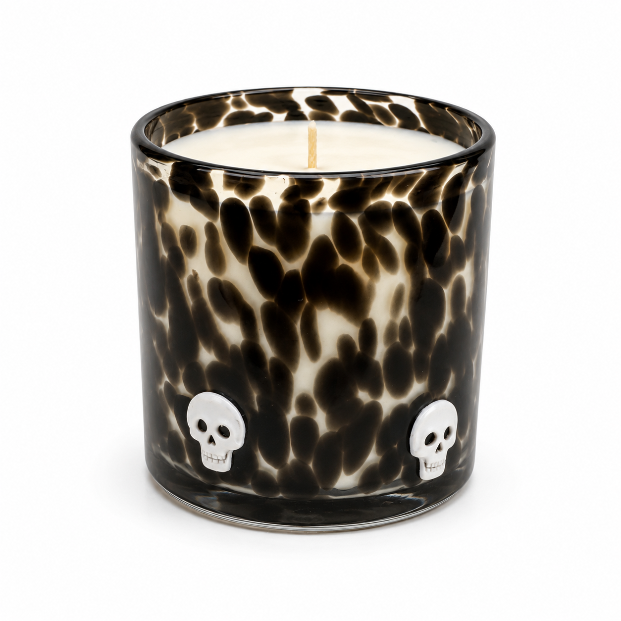 Halloween artisan candle with white skulls on a black speckled glass vessel