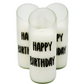 The "Happy Birthday" Recycled Curve Cut Candle features three white natural wax candles in glass holders made from recycled wine bottles, each with “HAPPY BIRTHDAY” in black, arranged in a triangle on a white background.