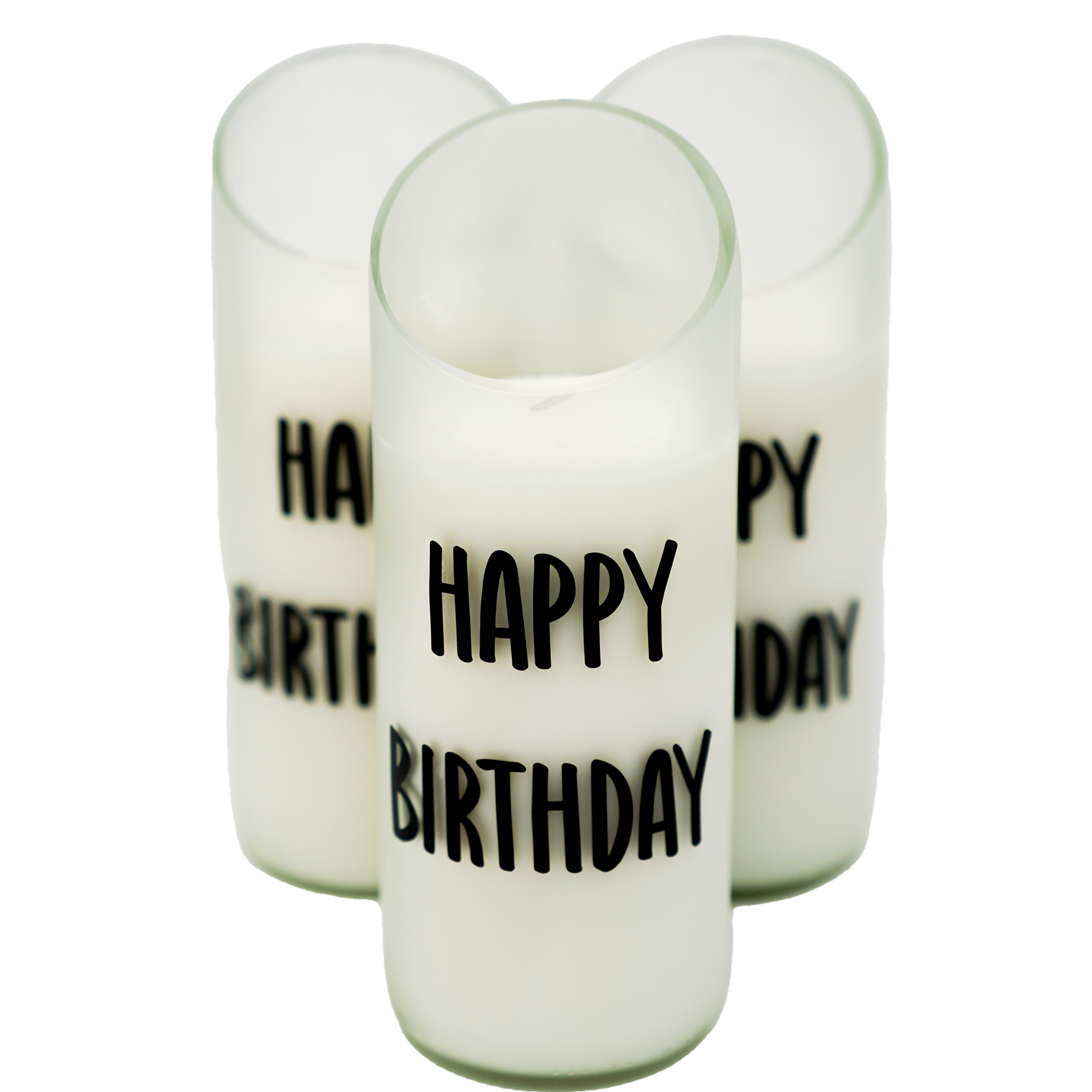 The "Happy Birthday" Recycled Curve Cut Candle features three white natural wax candles in glass holders made from recycled wine bottles, each with “HAPPY BIRTHDAY” in black, arranged in a triangle on a white background.