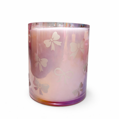 Iridescent Bow Candle with pink bow design on a white background