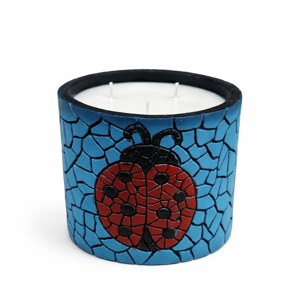 Candle in a blue mosaic holder with a ladybug design on a white background