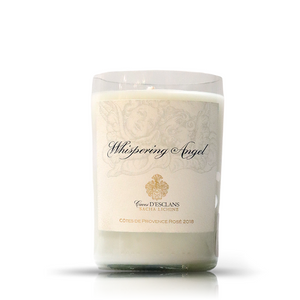 The Recycled Whispering Angel Rose Wine Candle is a white upcycled candle in a glass holder with a "Whispering Angel, Caves D'Esclans, Côtes de Provence Rosé 2018" label—ideal for fans of wine bottle candles and eco-friendly décor.