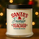 The Santa's Favorite Teacher Candle with Matches is a white, all natural wax candle in a glass jar with a black lid, labeled in festive red and green.