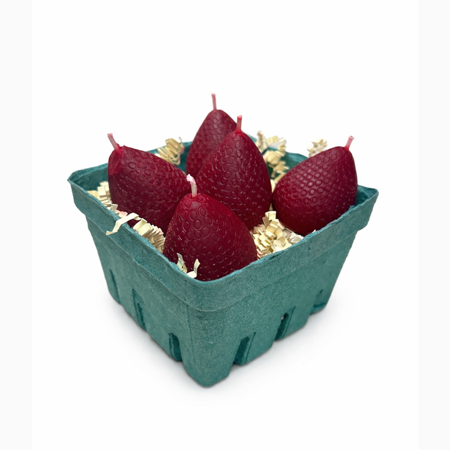 5 Red strawberry-shaped candles in a green cardboard box on a white background