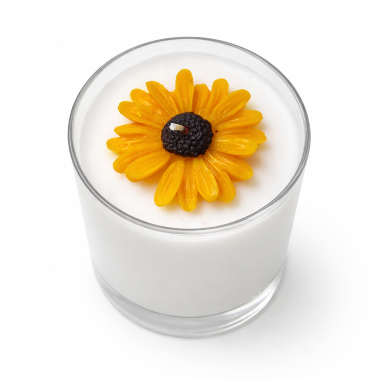 Candle with a yellow flower on top against a white background